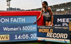 Kenya's Faith Kipyegon poses with her time after breaking the world record in the women's 5,000m