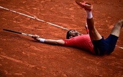 Champion: Novak Djokovic lays on the court as he celebrates his title victory 
