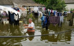Local resident Yuriy walks in the flooded yard of his house in Afanasiyivka