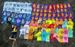 Surya Wijaya Ang poses with his collection of Lionel Messi jerseys in Banda Neira, Indonesia