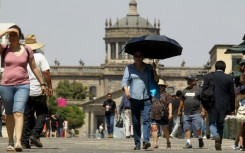 Pedestrians shield themselves from the sun in the city of Guadalajara in Mexico's Jalisco state
