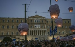 Protesters release hot air balloons in front of the Greek parliament as a tribute to the victims of the disaster