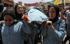Palestinian schoolgirls mourn their 15-year-old classmate Sadil Naghnaghiya, in Jenin in the occupied West Bank