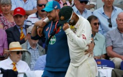 Australia's Nathan Lyon is helped off the field