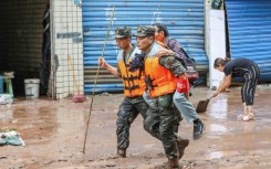 Paramilitary policemen evacuate a resident after flooding in Chongqing