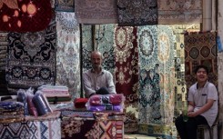 A rug vendor waits for customers in the old market of Iran's central city of Yazd 