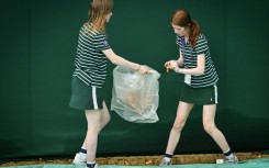 Ball girls pick up orange confetti thrown by climate activists at Wimbledon