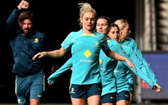 Australia's Ellie Carpenter (C) and her teammates go through their stretching exercises during a training session