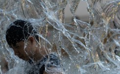 A man cools off in a water playground at a park in eastern Tokyo, as high temperatures bake Japan's capital