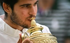Champion: Carlos Alcaraz kisses the winner's trophy after beating Novak Djokovic 