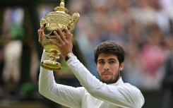 Champion: Carlos Alcaraz raises his trophy after beating Novak Djokovic 