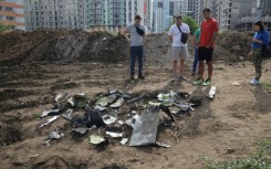 People look at fragments of a missile shot down during a night strike in Odesa, Ukraine on July 19, 2023