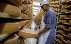 File: A Gruyere cheese wheel is checked during maturing operation in a giant cellar in Bulle, western Switzerland. AFP/Fabrice Coffrini