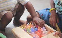 File: Children playing with chalk crayons.