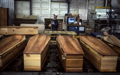 File: At a factory belonging to Europe's largest coffin maker, OGF, workers are doing overtime to meet demand from families parting with their loved ones.