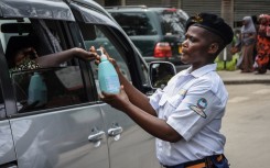 A security officer dispenses hand sanitizer to a passenger at Muhimbili National Hospital in Dar es Salaam, Tanzania.