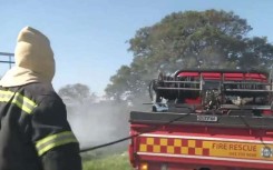 A firefighter next to a vehicle.
