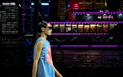 Dozens of models in dark blues and pastels paraded down the riverfront catwalk that took Shanghai's Oriental Pearl Tower as a backdrop