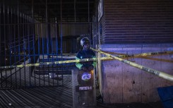 A private security guard stands at the scene of a fire in Johannesburg. AFP/Michele Spatari
