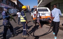 A private security guard carries his weapon as Johannesburg City Power employees move a large copper cable during an operation with the JMPD aimed to cut illegal power connection. AFP/Emmanuel Croset