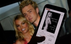 This illustration image shows the cover of Britney Spears' book "The Woman in Me" from an online retailer in front of a picture of Spears and Justin Timberlake. AFP/Chris Delmas