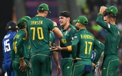 Gerald Coetzee (C) celebrates with teammates after taking the wicket of England's captain Jos Buttler during the 2023 ICC Men's Cricket World Cup ODI match. AFP/Punit Paranjpe