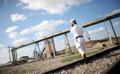 File: A mine worker walks to work. AFP/Paballo Thekiso