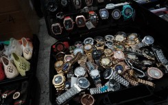 File: Knock-off luxury watches are displayed by sellers along a sidewalk. Spencer Platt/Getty Images/AFP 