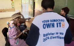 Two women give their identity documents to IEC officials to be registered as voters. AFP/Luca Sola
