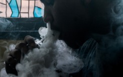 This photo illustration shows a customer smoking at a vape store.