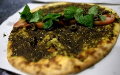 A traditional Lebanese manoushe flatbread topped with mint, tomatoes and olives. AFP/Joseph Eid