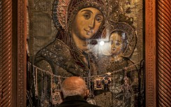 A Christian worshipper prays before the Bethlehemitissa icon of the Virgin Mary with the Child Jesus. AFP/Hazem Bader