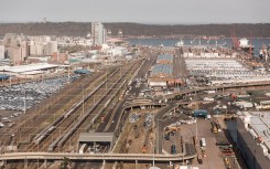 Trucks and cargo vessels are seen at the Port of Durban harbour.