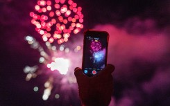 A person filming fireworks.