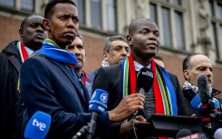South Africa's Minister of Justice Ronald Lamola (R) delivers remarks to journalists outside the International Court of Justice (ICJ) after the first day of hearings on the genocide case against Israel brought by South Africa, in The Hague on January 11, 2024. 