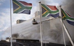 File: Firefighters extinguish a fire burning in the National Assembly, the main chamber of the South African Parliament buildings, on January 03, 2022, in Cape Town.