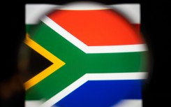 File: View of the South African flag with a magnifying glass.