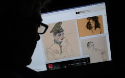 a person looking on a computer screen at artwork by Austrian Expressionist Egon Schiele entitled "Russian War Prisoner" (L), "Portrait of a Man" (R) and "Girl With Black Hair" (top), which were seized by investigators. AFP/Chris Delmas