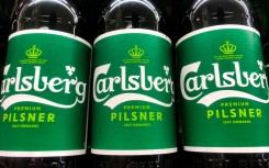 Carlsberg logos are seen on beer bottles. Jakub Porzycki/NurPhoto via AFP