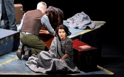 Cast members sit within a concrete Star of David divided into sections representing the rooms in the "secret annex" where the Frank family and four others hid. AFP/Nick Gammon