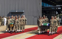 SANDF members carry the flag-draped coffins of Captain Simon Mkhulu Bone and Lance Corporal Irven Thabang Semono during a ceremony at the Waterkloof Air Force Base. AFP/Marco Longari