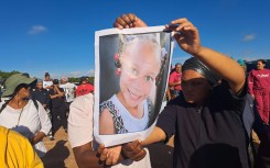Community members holding a photo of Joshlin Smith. eNCA/Nobesuthu Hejana