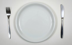 File: Fork and knife next to an empty, white plate in a restaurant. AFP/Thomas Eisenhuth/dpa-Zentralbild