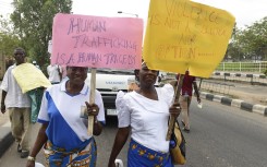 File: Women carry placards at a protest march against violence, trafficking and child abuse. AFP/Pius Utomi Ekpei