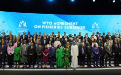 Delegates take a group picture during a session on fisheries subsidies during the 13th WTO Ministerial Conference in Abu Dhabi. AFP/Giuseppe Cacace