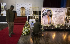 Soldiers lay flowers near a commemorative photograph of SANDF Lance Corporal Thabang Semono. AFP/Olympia De Maismont