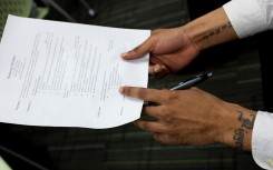 File: A job seeker holds his CV before and interview. Brooks Kraft LLC/Corbis via Getty Images