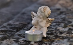 A cherub next to a candle. Pixabay/pasja1000