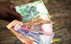 File: A man holds South African banknotes. AFP/Phill Magakoe 