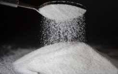File: A person dumps sugar onto a table with a spoon. AFP/Thibaut Durand/Hans Lucas